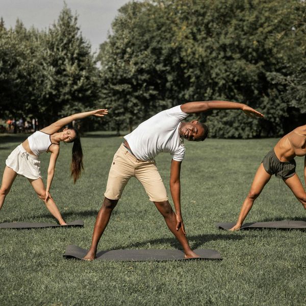Diverse group of people smiling during a calm yoga practice.